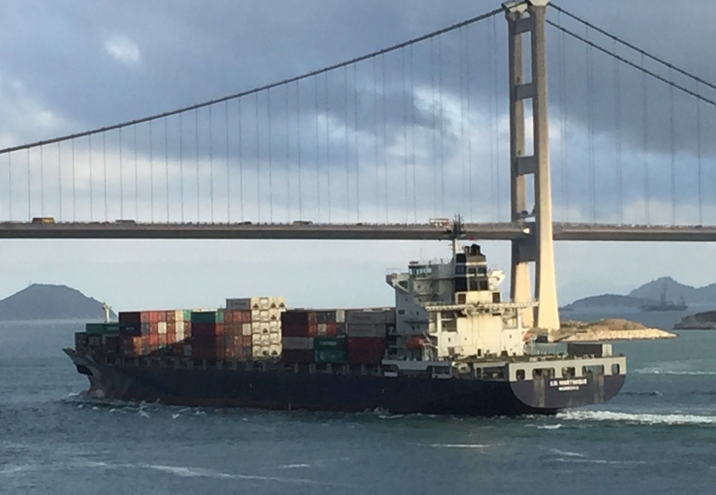 Container ship under way beneath a suspension bridge - photograph by Simon Daniels